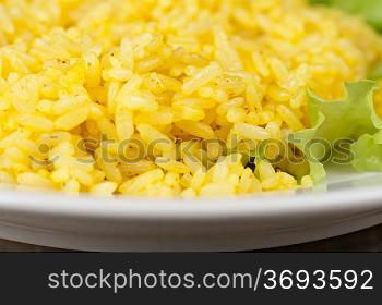 golden rice with lettuce at plate closeup