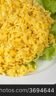 golden rice with lettuce at plate closeup