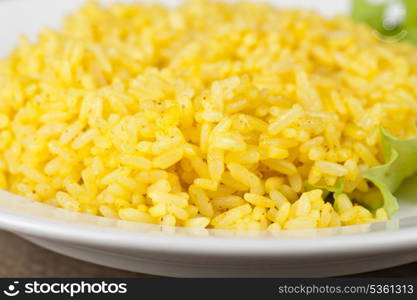 golden rice with lettuce at plate closeup