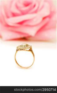 Golden ring and rose at the background