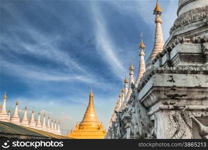 Golden Sandamuni Pagoda with row of white pagodas. Amazing architecture of Buddhist Temples at Mandalay. Myanmar (Burma) travel landscapes and destinations