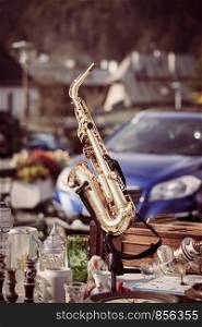 Golden saxophone on a flea market, outdoors