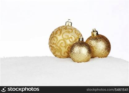 Golden shiny Christmas balls on snow