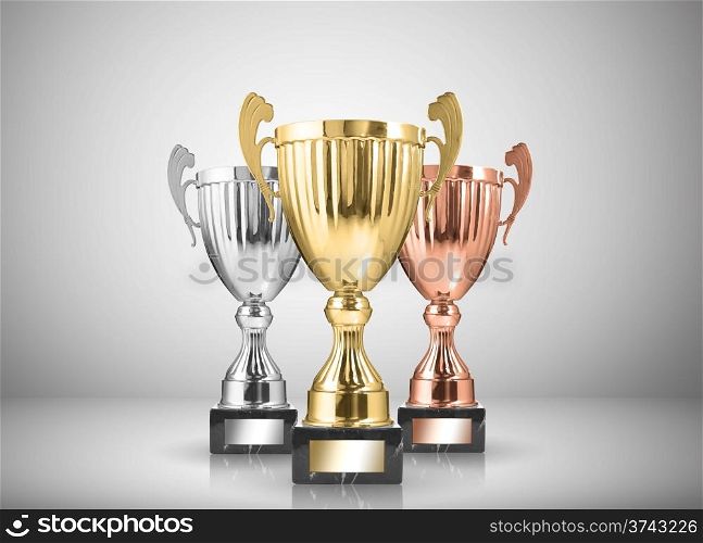 golden,silver and bronze trophies on gray background