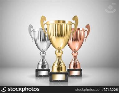 golden,silver and bronze trophies on gray background