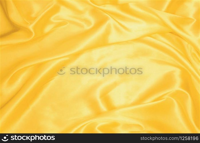 Golden smooth satin or silk texture background. Elegant cloth material textiles. White fabric abstract texture. Luxury satin velvet. Silky and wavy folds of silk texture. Rippled satin cloth