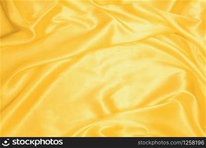 Golden smooth satin or silk texture background. Elegant cloth material textiles. White fabric abstract texture. Luxury satin velvet. Silky and wavy folds of silk texture. Rippled satin cloth