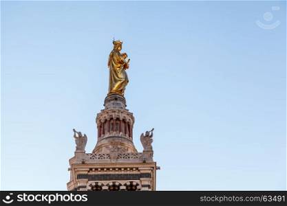 Golden Statue of the Madonna Holding the little Jesus on the top of Notre-Dame de la Garde in Marseilles, France