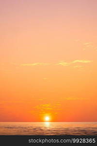 Golden sunset sky vertical background over sea with yellow sunlight cloud on idyllic orange dusk sky and light reflection on water surface, beautiful nature tranquil seascape in minimal style