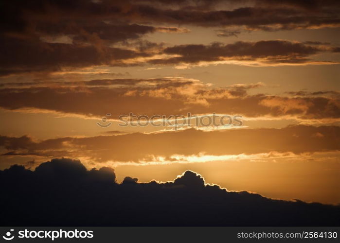 Golden sunset with glowing cloud edges in Maui, Hawaii, USA.