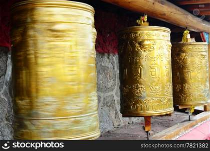 Golden Tibetan prayer wheels in a lamasery