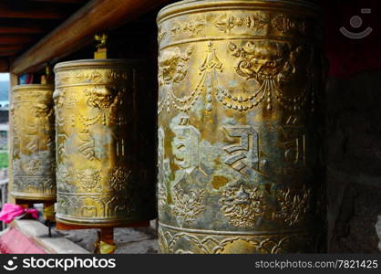 Golden Tibetan prayer wheels in a lamasery