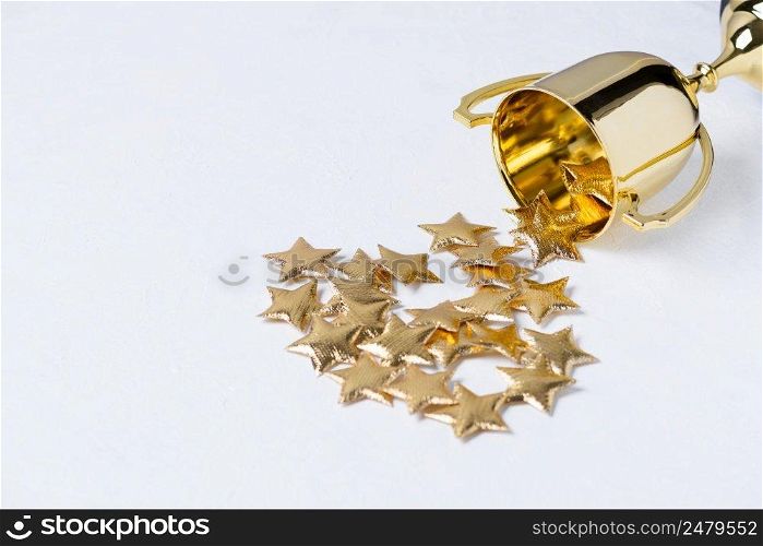 Golden trophy cup with golden stars on white textured background
