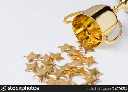 Golden trophy cup with golden stars on white textured background