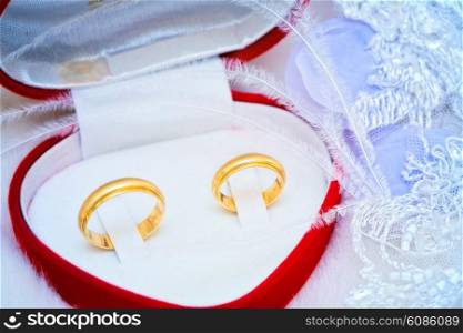 golden wedding rings in a heart box