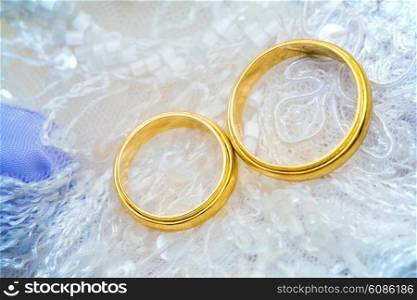 golden wedding rings on lace with shallow DOF