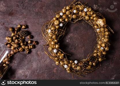 Golden woven natural wreath with acorns and pine cones. Golden woven wreath