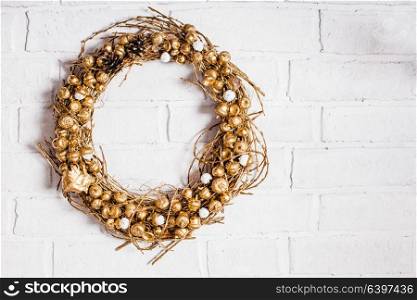 Golden woven natural wreath with acorns and pine cones. Golden woven wreath
