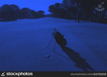 golf bag on course. golf bag on course with club and ball in front at beautiful sunrise duo tone