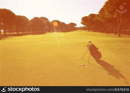 golf bag on course with club and ball in front at beautiful sunrise. golf bag on course