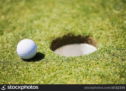 Golf ball at the edge of a hole