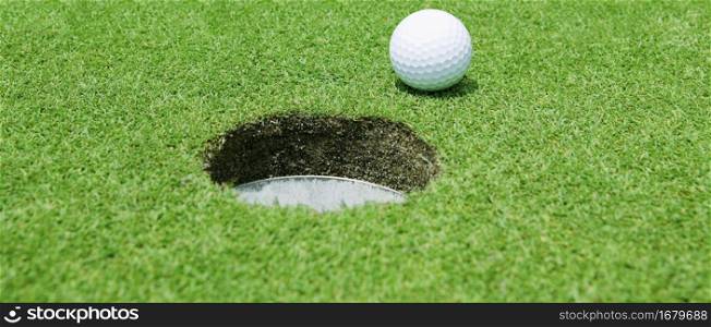 Golf ball near the hole close up. Golf ball near the hole