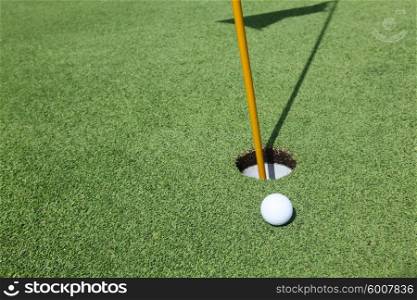 Golf ball near the hole. Close-up of a golf ball near the hole