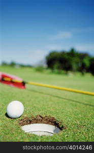 Golf ball next to hole