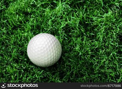 golf ball on green course in front of driver