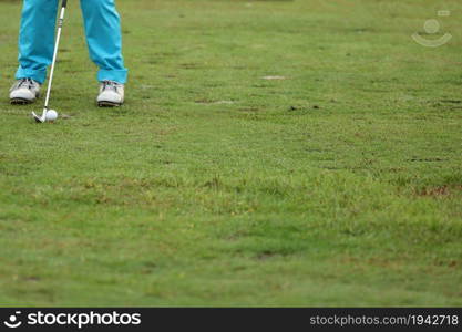 Golf ball on green grass ready to be struck on grass background