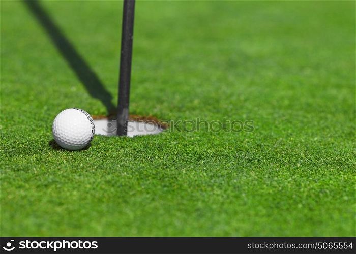 golf ball on lip of cup close up. golf ball on lip of cup