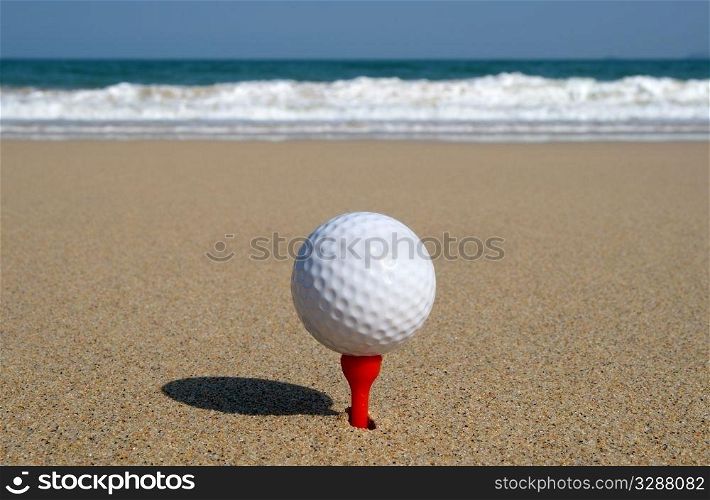 Golf ball on the beach, ready to be hit in to the ocean.