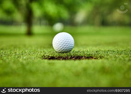 Golf ball on the green. golf ball on lip of cup