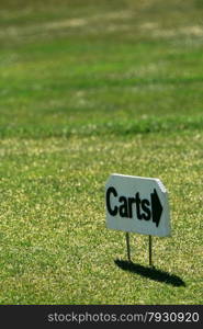 Golf cart directional sign in the grass