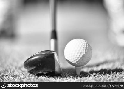 Golf club and ball in grass