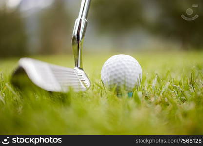 Golf club and ball on tee in front of driver