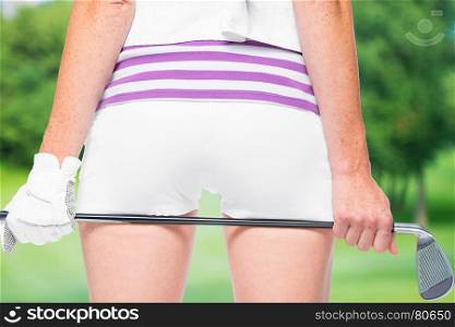 Golf club in woman hands on ass background on a background of golf courses