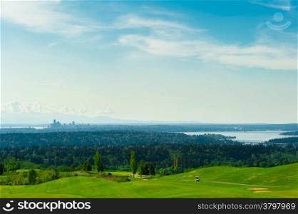 Golf course with green grass and Seattle downtwon at the background. A relaxing and fun activity for weekends.