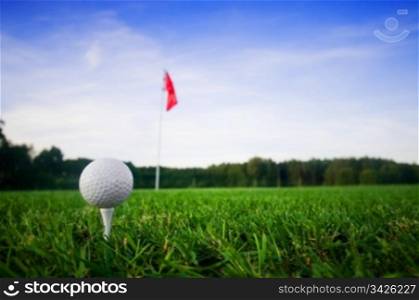 Golf field with green grass and red flag.