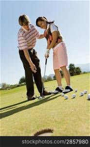 Golf Instructor Teaching Student to Putt