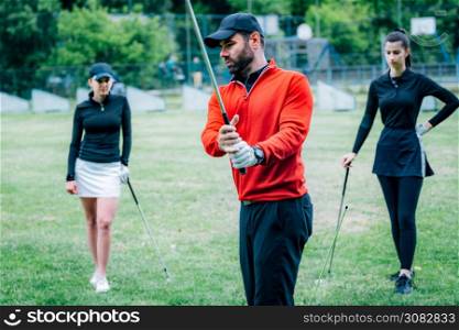 Golf lesson. Golf instructor showing swing technique to young women