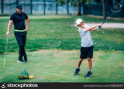Golf Lesson. Golf Instructor Teaching Young Boy How to Swing . Personal Golf Lessons. Golf Instructor Adjusting Swing of a Young Boy.
