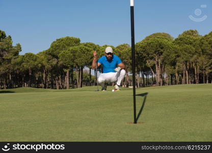 golf player aiming shot with club on course at beautiful sunny day