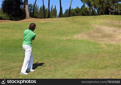Golf Player chipping his ball on the green, near the hole
