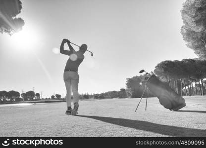 golf player hitting shot with club on course at beautiful morning black and white