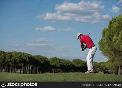 golf player hitting shot with driver on course at beautiful sunny day