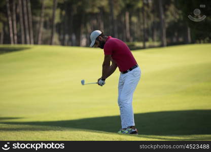 golf player hitting shot with driver on course at beautiful sunny day