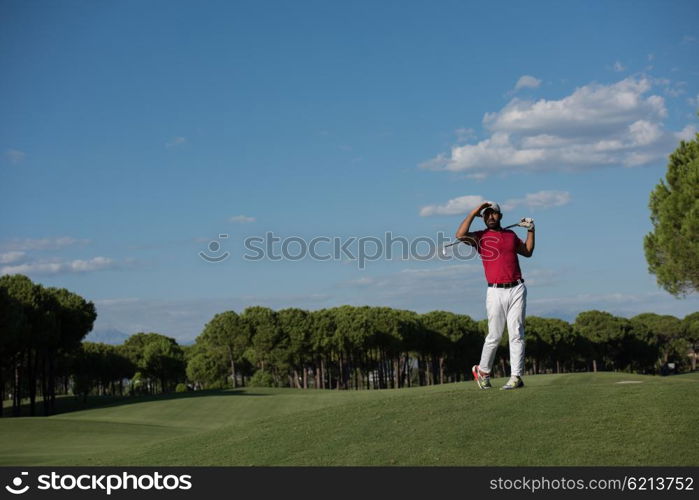 golf player hitting shot with driver on course at beautiful sunny day