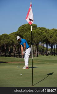 golf player hitting shot with driver on course at beautiful sunny day