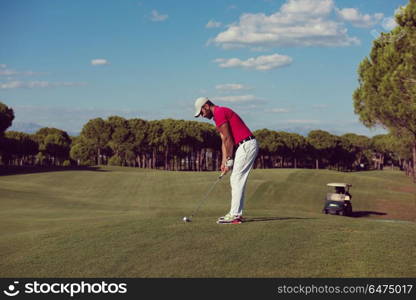 golf player hitting shot with driver on course at beautiful sunny day. golf player hitting long shot